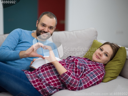 Image of man and pregnant woman showing heart sign