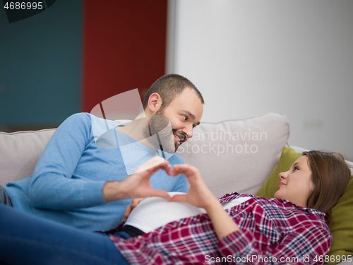 Image of man and pregnant woman showing heart sign