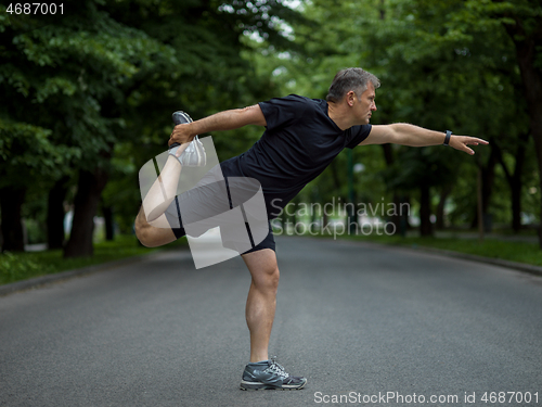 Image of male runner warming up and stretching before morning training