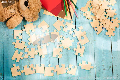 Image of Concept of mock up and pieces of puzzles on the background of wooden table