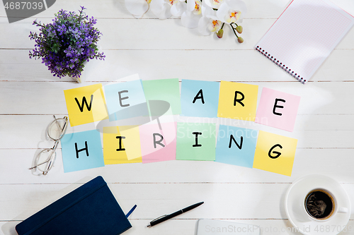 Image of WE ARE HIRING. Message at colorful note papers on a desk