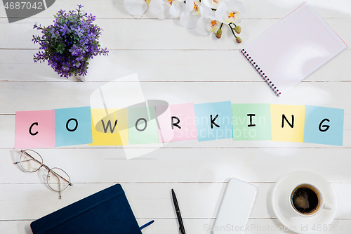 Image of COWORKING. Message at colorful note papers on a desk background.