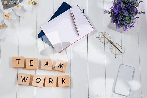 Image of TEAM WORK. Message at at wooden cubes on a desk background.