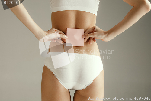 Image of Young adult woman holding empty paper card for sign or symbol.