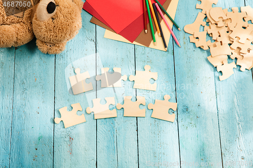 Image of Concept of mock up and pieces of puzzles on the background of wooden table