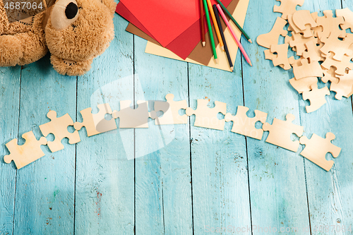 Image of Concept of mock up and pieces of puzzles on the background of wooden table