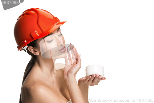 Image of Portrait of confident female worker in orange helmet