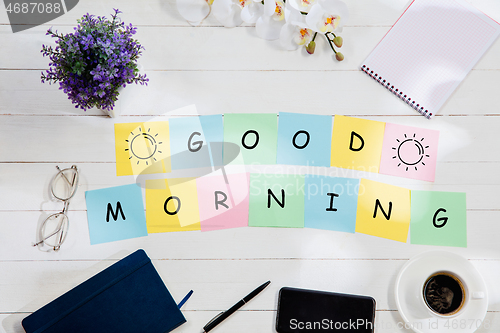 Image of GOOD MORNING. Message at colorful note papers on a desk background.