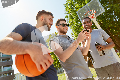 Image of men with smartphone on basketball playground
