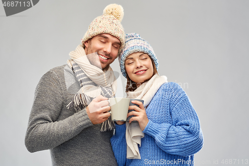 Image of happy couple in winter clothes with mugs