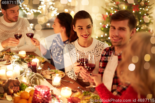 Image of happy friends celebrating christmas at home feast