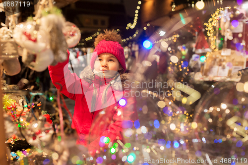 Image of girl choosing christmas decorations at market