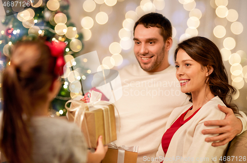 Image of happy family with christmas present at home