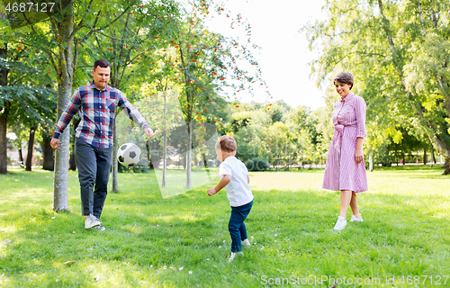 Image of happy family playing soccer at summer park