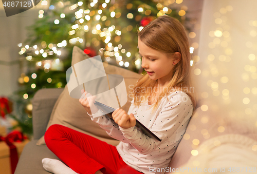 Image of smiling girl with tablet pc at christmas home