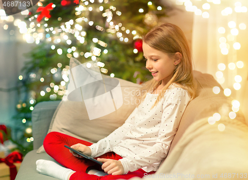 Image of smiling girl with tablet pc at christmas home