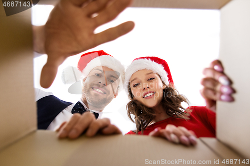 Image of happy couple opening christmas gift box