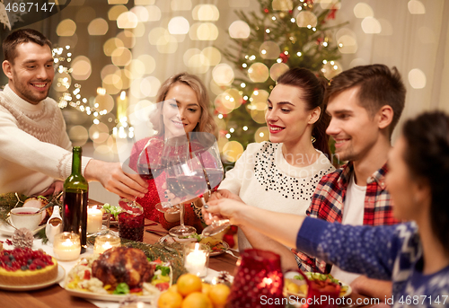 Image of friends celebrating christmas and drinking wine