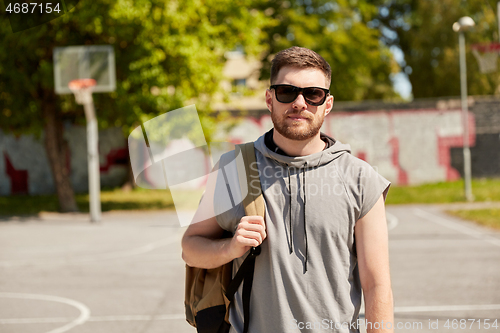 Image of man with backpack at street basketball playground