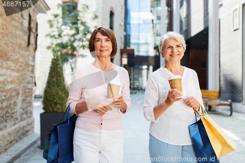 Image of senior women with shopping bags and coffee in city