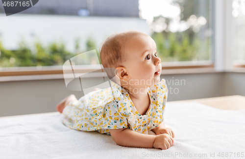 Image of sweet baby girl lying on white blanket