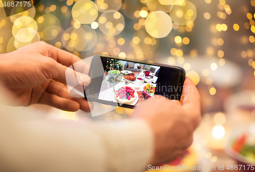 Image of hands photographing food at christmas dinner