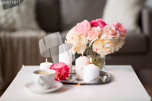 Image of coffee, candles, garland and flowers on table