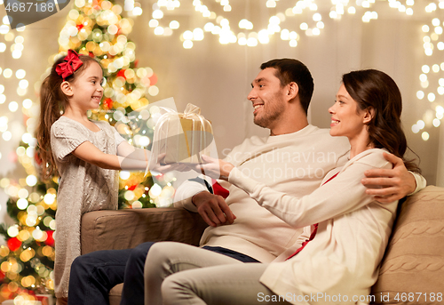 Image of happy family with christmas present at home