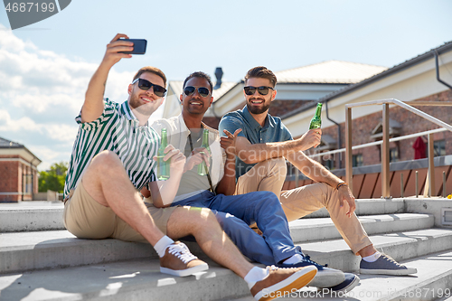Image of men drinking beer and taking selfie by smartphone