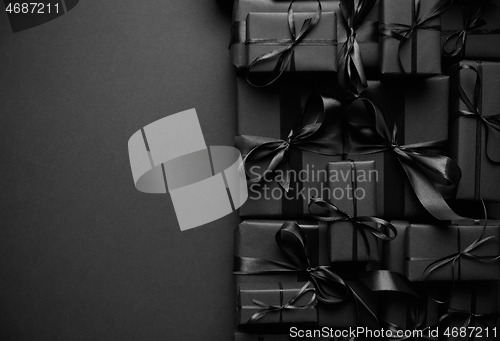 Image of A pile various size black boxed gifts placed on stack. Christmas concept.