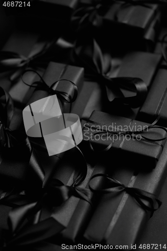 Image of A pile various size black boxed gifts placed on stack. Christmas concept.