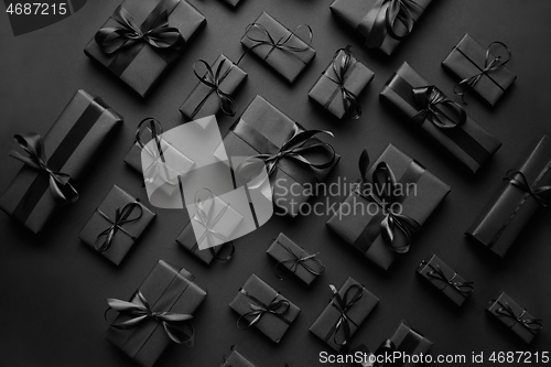 Image of Elegant black Christmas theme. Wrapped gifts in black matte paper with ribbon