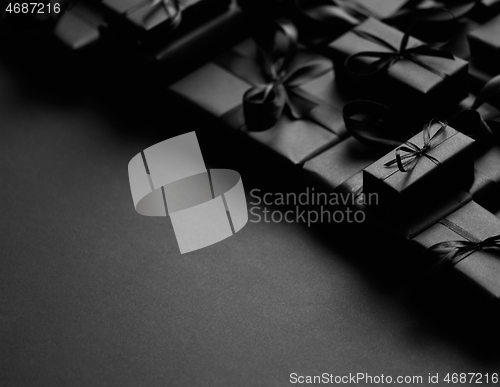 Image of A pile various size black boxed gifts placed on stack. Christmas concept.