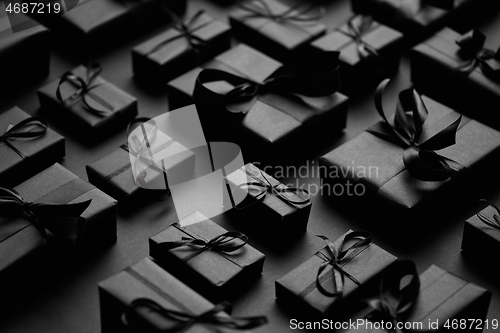 Image of Elegant black Christmas theme. Wrapped gifts in black matte paper with ribbon