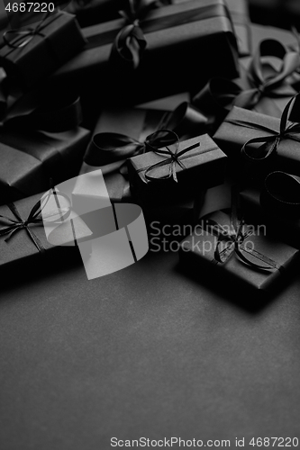 Image of A pile various size black boxed gifts placed on stack. Christmas concept.