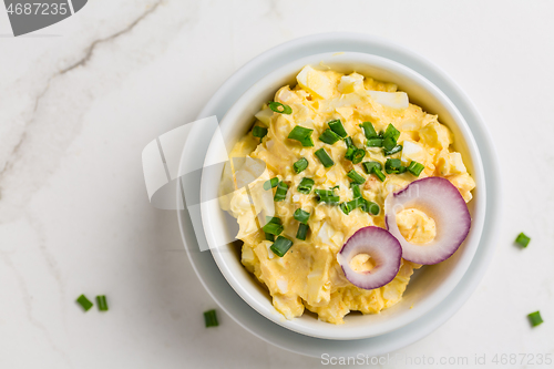Image of Egg spread with onion and chives on marble background