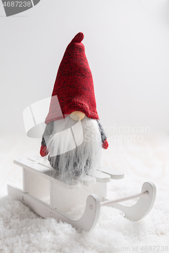 Image of Christmas imp on sleigh with snowy landscape