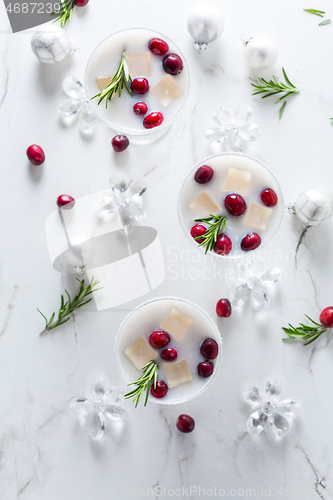 Image of White Christmas margarita punch with cranberries and rosemary