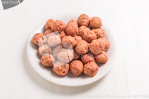 Image of Raw meatballs on plate and white background