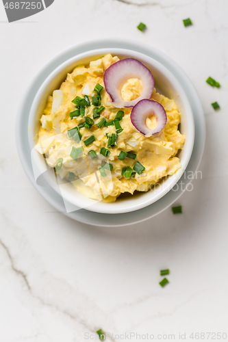 Image of Egg spread with onion and chives on marble background