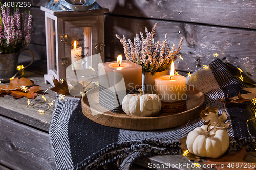 Image of Autumn terrace or patio in night with pumpkins and heather plant 