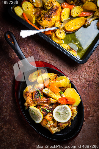 Image of Baked lemon chicken with potatoes, carrots and herbs served in pan