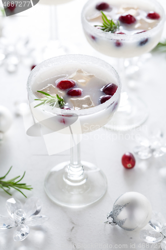 Image of White Christmas margarita punch with cranberries and rosemary