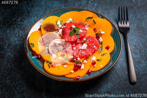 Image of Persimmon carpaccio salad with pomegranate, feta cheese, pink grapefruit and figs