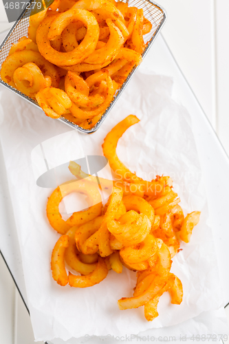 Image of Spicy seasoned curly fries. Ready to eat.