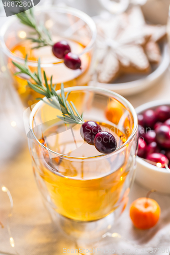 Image of Christmas apple cider cocktail with cranberries and rosemary