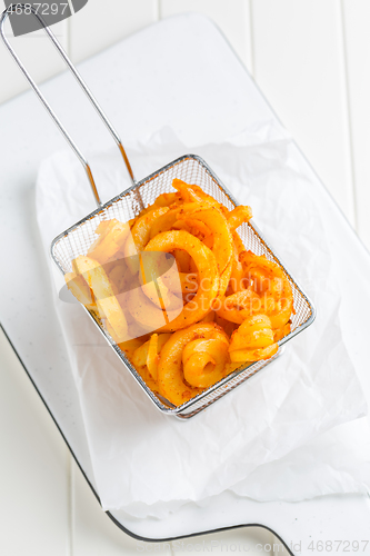 Image of Spicy seasoned curly fries. Ready to eat.