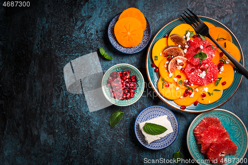 Image of Persimmon carpaccio salad with pomegranate, feta cheese, pink grapefruit and figs