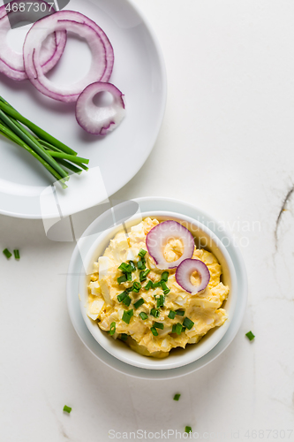 Image of Egg spread with onion and chives on marble background