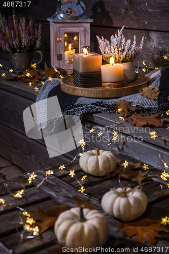 Image of Autumn terrace or patio in night with pumpkins and heather plant 